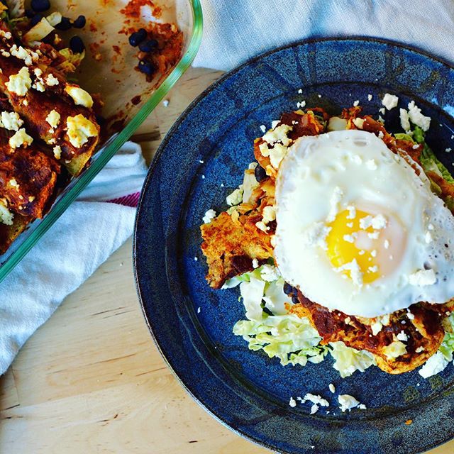 Black Bean And Cabbage Enchiladas In Pumpkin Sauce Topped With Over Easy Eggs And Cheese by